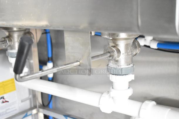 Close-up of a stainless steel valve and piping system under a sink in a Rock Solid Cargo fast food trailer.