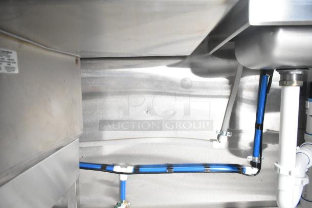 Interior view of a brand new 2021 Rock Solid Cargo 24' mobile kitchen trailer, showing plumbing and stainless steel fixtures.