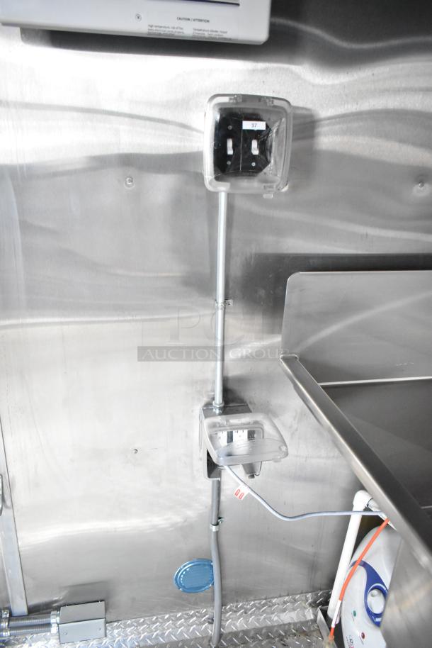 Interior view of a 2021 Rock Solid Cargo fast food trailer showing electrical outlets and stainless steel fixtures.