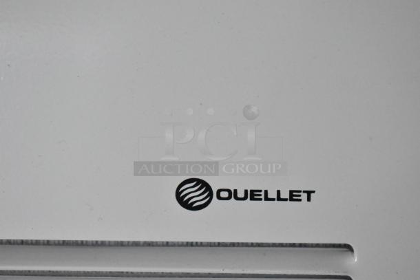Alt text: Close-up of Ouellet logo on white surface of Rock Solid Cargo fast food trailer.