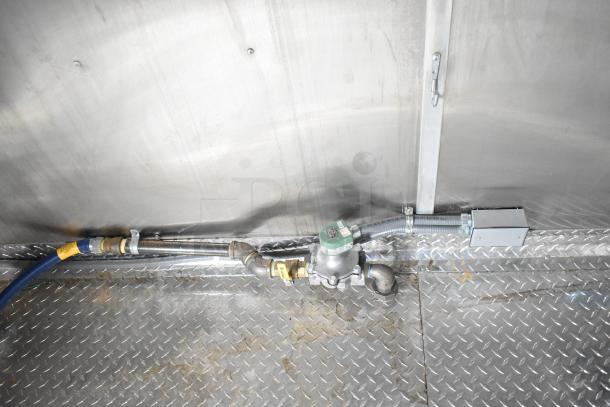 Interior view of a 2021 Rock Solid Cargo fast food trailer showing plumbing and wiring fixtures on diamond plate flooring.