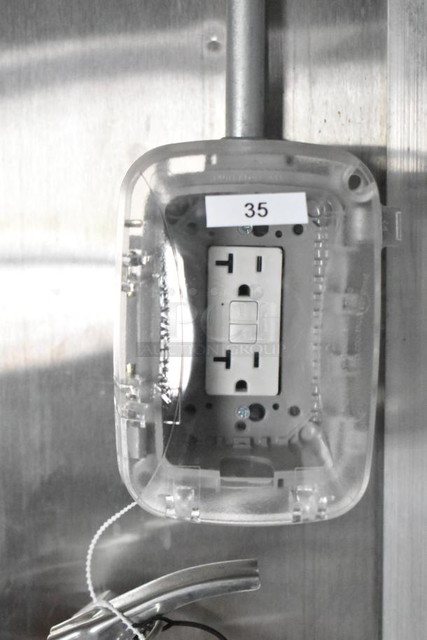 Electrical outlet with protective cover inside a brand new Rock Solid Cargo 24' fast food trailer, labeled "35".