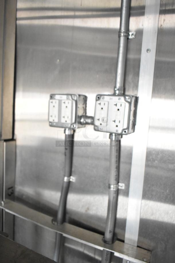 Stainless steel interior of 2021 Rock Solid Cargo 24' fast food trailer with visible electrical outlets and conduit wiring.