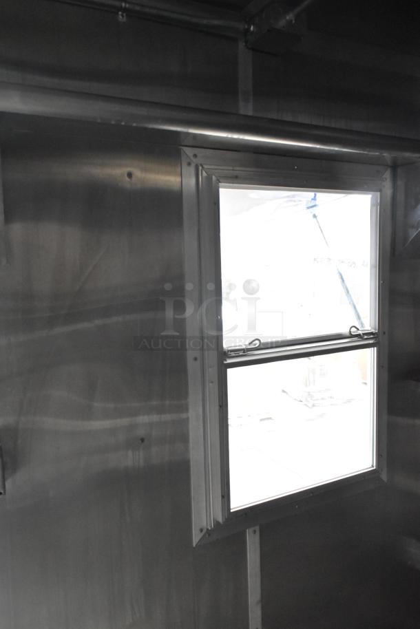 Brand new 2021 Rock Solid Cargo 24' mobile kitchen trailer interior featuring a window. Stainless steel surfaces visible.