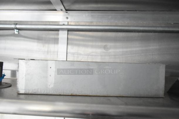 Rock Solid Cargo mobile kitchen trailer interior, featuring shelving and industrial fixtures. No equipment visible.