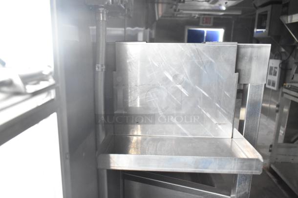 Interior of brand new 2021 Rock Solid Cargo 24' mobile kitchen trailer with stainless steel fixtures and commercial equipment.
