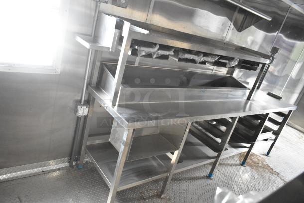 Brand new 2021 Rock Solid Cargo 24' fast food trailer interior, featuring stainless steel prep area and shelving.