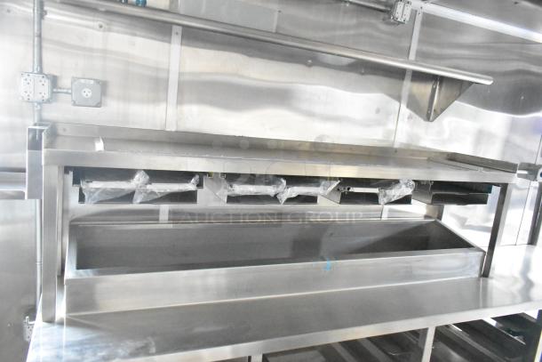 Brand new Rock Solid Cargo 24' mobile kitchen interior. Features stainless steel surfaces, equipment mounts, and electrical outlets.