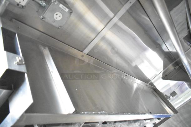 Brand new 2021 Rock Solid Cargo 24' mobile kitchen interior, stainless steel surfaces, outlets, and CaptiveAire grease hood visible.