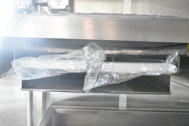 Interior view of a brand new 2021 Rock Solid Cargo 24' mobile kitchen trailer, showing wrapped commercial equipment.