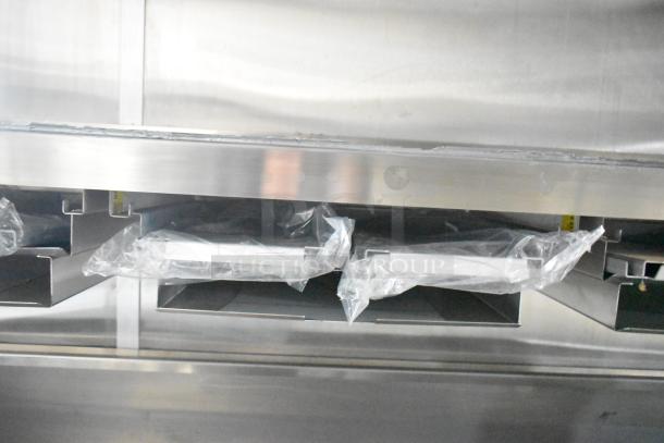 Rock Solid Cargo 24' mobile kitchen trailer interior with CaptiveAire grease hood, wrapped in original packaging, showing stainless steel surfaces.