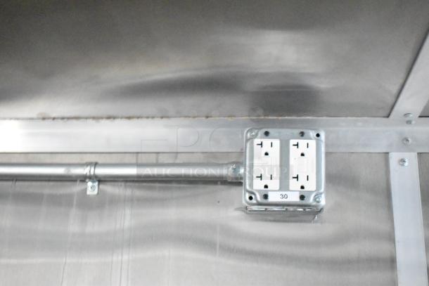 Electrical outlet inside a brand new 2021 Rock Solid Cargo 24' fast food trailer. Labeled "30" in a stainless steel interior.