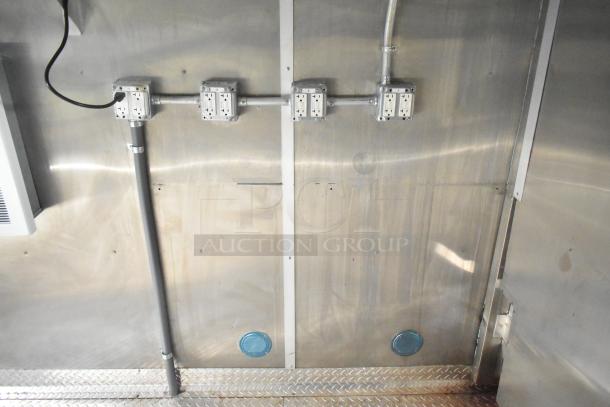 Interior view of a brand new 2021 Rock Solid Cargo Burger King fast food trailer, featuring electrical outlets and wiring on stainless steel walls.
