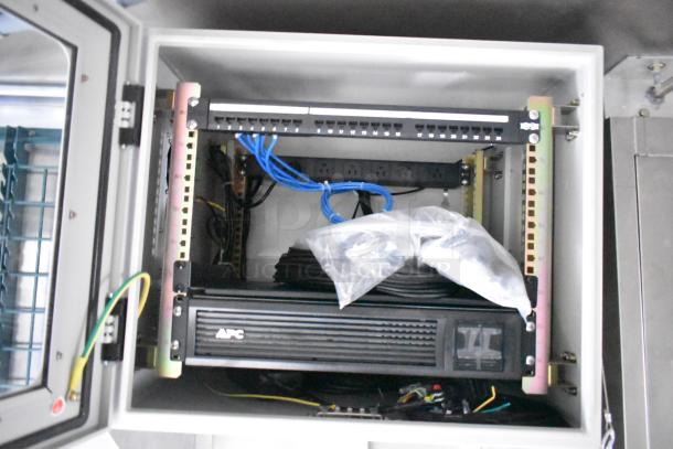 Interior view of a 2021 Rock Solid Cargo mobile kitchen showing networking equipment and cables, in new condition.