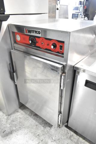 Wittco 1001 commercial heated holding cabinet on casters. 208/240V, 1 phase. Features include control dials and a "Caution Hot" label.