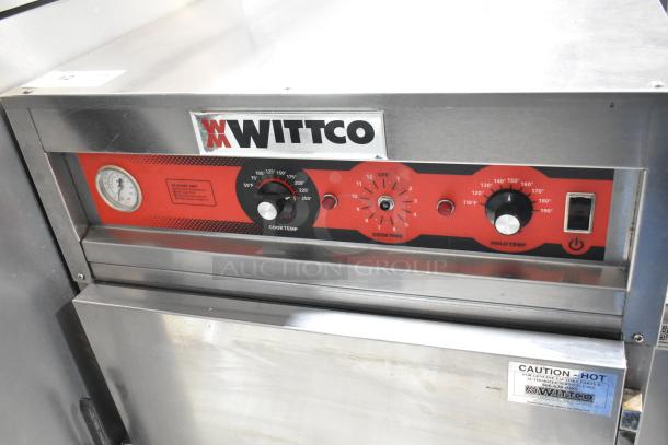 Wittco 1001 heated holding cabinet on casters, 208/240V, 1 Phase. Features temperature dials, caution label, and sturdy build.