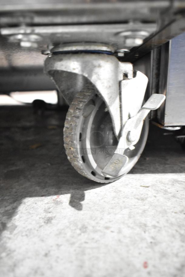 Wittco 1001 Commercial Heated Holding Cabinet caster, showing sturdy wheel with lock mechanism. 208/240 Volts, 1 Phase.