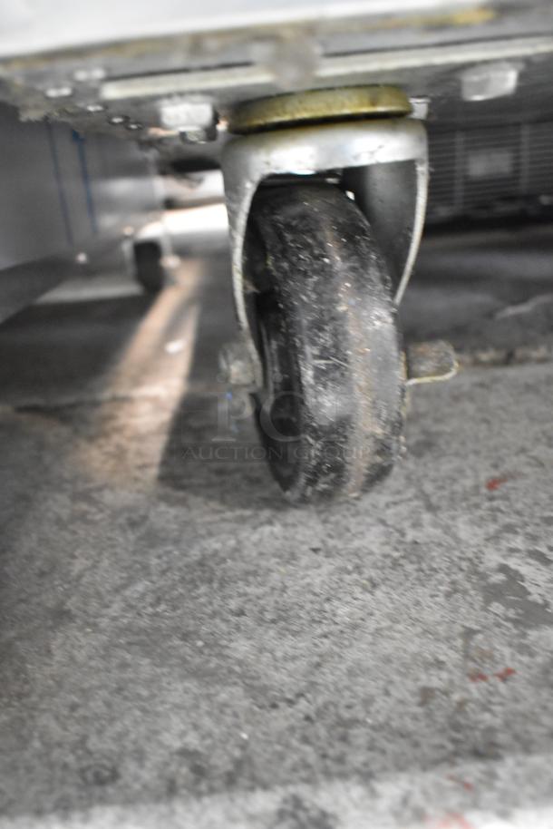 Traulsen G12010 commercial freezer on caster. Single door, 115 volts, 1 phase. Close-up of the caster wheel.