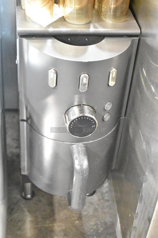 Commercial countertop coffee tower machine, stainless steel. Features dials, spouts, and multiple compartments; used condition.