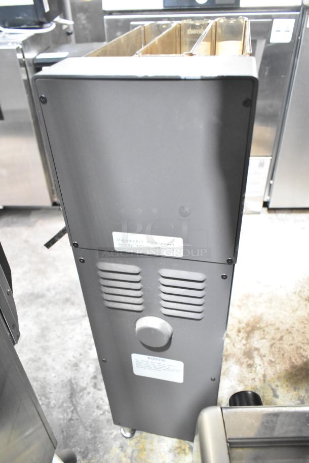 Commercial countertop coffee tower, gray with warning labels, showing power and maintenance instructions. Used condition.