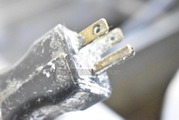 Close-up of a worn, three-prong electrical plug for the Univex SDR1411-01 dough divider.