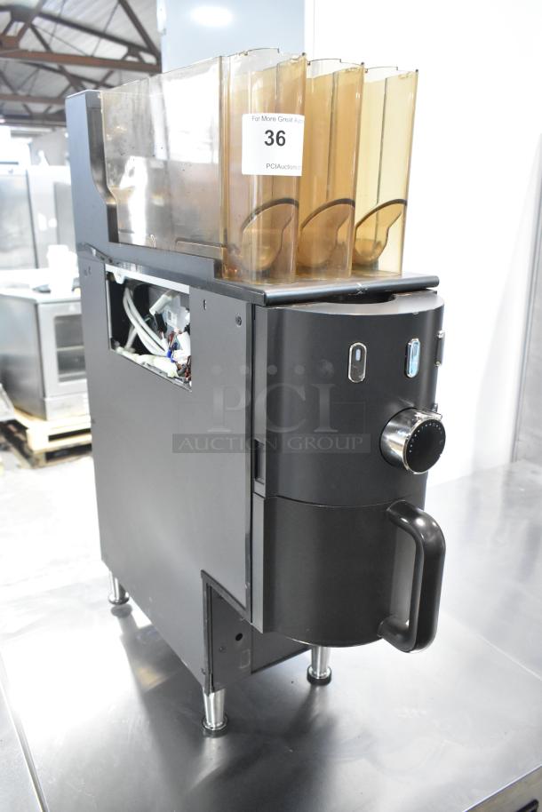 Commercial countertop coffee tower machine, black with chrome accents, featuring multiple compartments, in used condition.