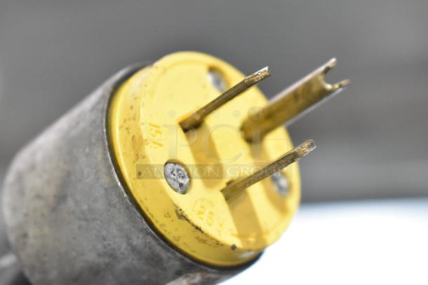 Yellow electrical plug showing 15A, 125V markings on a Leader deli display case merchandiser.