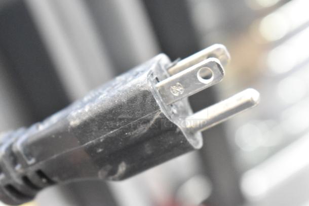 Close-up of a power plug with slight scratches, part of the new Hobart EDGE14-11 meat slicer, 115 volts, 1 phase.