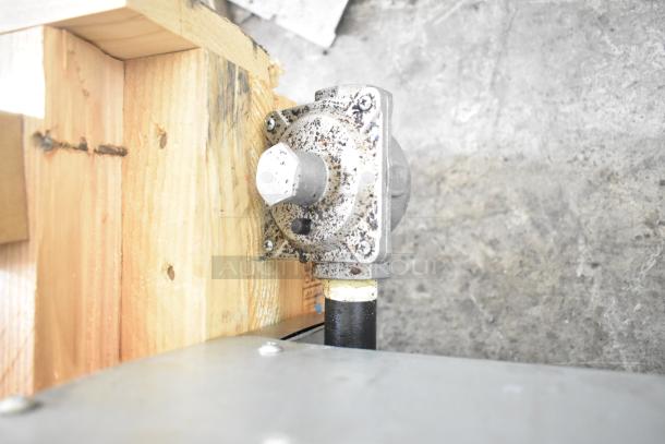 Natural gas valve linked to Avantco 177CAG36TG griddle, mounted on wood. Slight wear visible on valve surface.