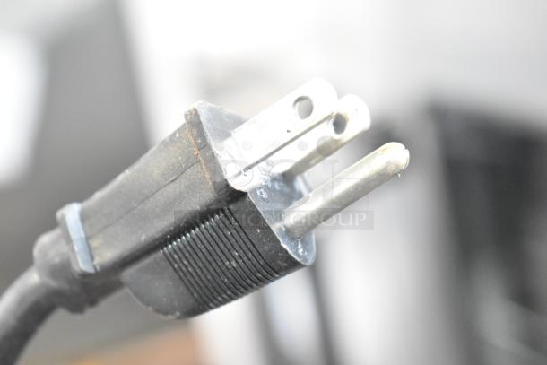 Close-up of a black power plug for the Gaggia Brera Espresso Machine, suitable for 115 volts, 1 phase.