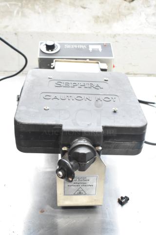 Sephra SERTWFL01 Countertop Waffle Baker, black, 110-120V, with caution markings, in used condition.