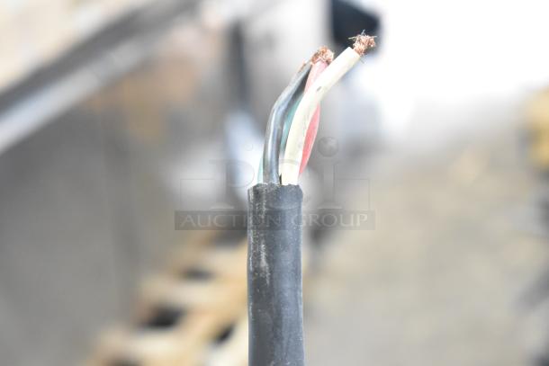 Close-up of exposed wires from a Hobart 6801 meat saw cable. Black casing shows worn insulation; wires include black, white, and red.