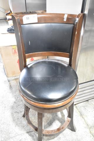 Bar height chair with wood pattern frame and black cushioned seat. Minor scratches on wood, tag indicating quantity of 55.