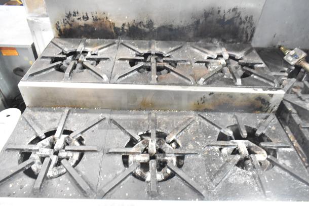 Jade Range commercial 6-burner gas range with oven, 2-tier surface, backsplash, and casters. Shows signs of use.