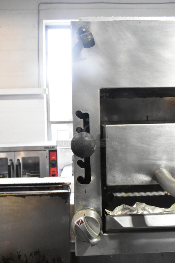 Southbend commercial gas-powered 6-burner range with oven and salamander cheese melter. Features stainless steel construction and control knobs.