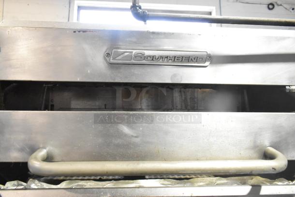 Southbend commercial gas range, 6 burners, oven, salamander cheese melter, backsplash, on casters, logo visible.