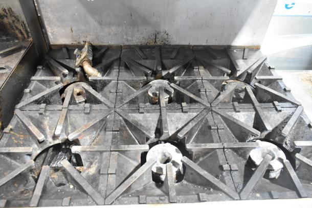 Southbend commercial gas-powered 6 burner range with oven, salamander cheese melter, backsplash, and commercial casters; used condition.