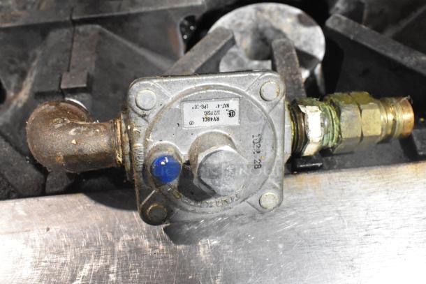 Regulator component on Southbend Commercial Gas 6 Burner Range. Features labeling and visible wear.