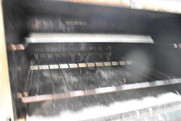 Southbend commercial gas range interior, featuring racks and salamander cheese melter, showing signs of wear.