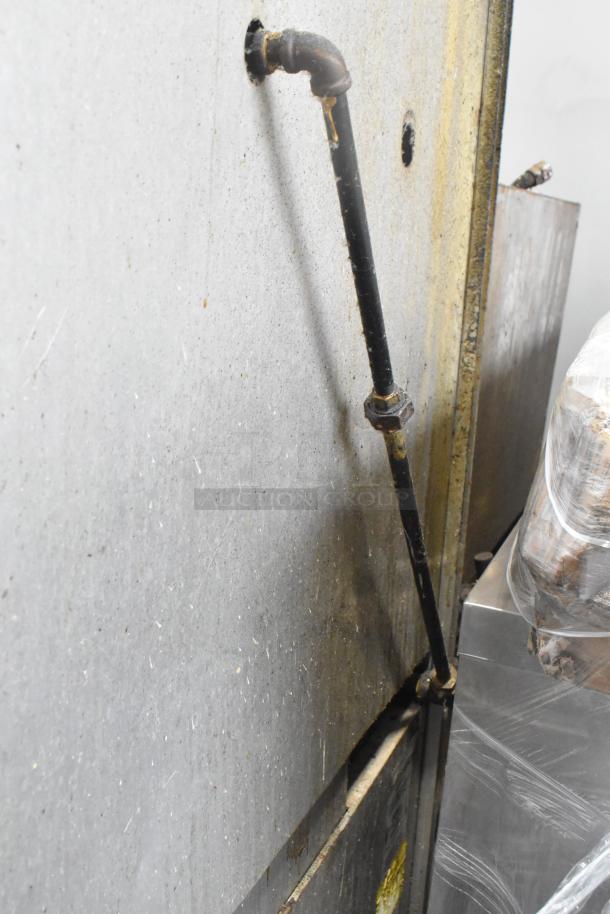 Southbend commercial gas range's back view showing connection pipe; visible wear and grime. Auction item condition details.