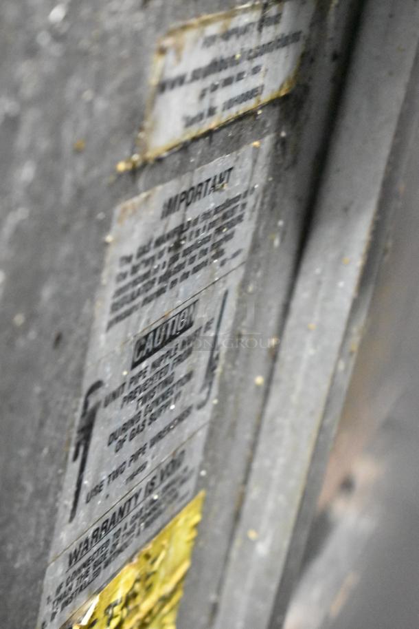 Southbend commercial gas-powered 6-burner range with oven, salamander cheese melter, backsplash, on commercial casters. Labels visible.