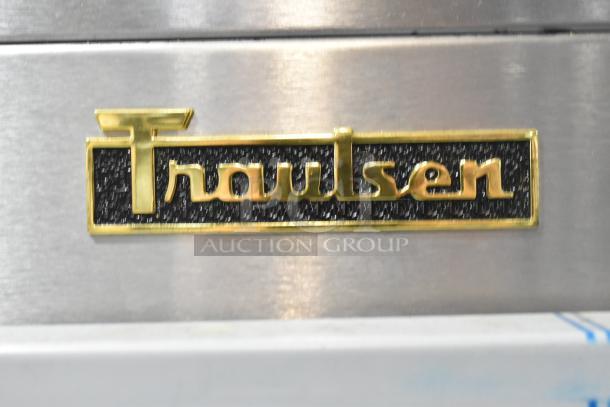 Alt text: Traulsen logo on stainless steel surface, part of a 2022 Traulsen G10042-032 commercial pass-through cooler.