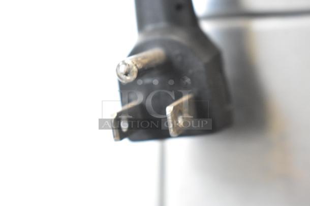 Close-up of power plug for a Traulsen G10042-032 commercial cooler, showing standard three-prong design for 115 volts.