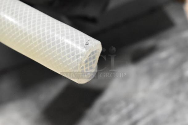 Close-up of a plastic hose with a textured exterior, part of the 2019 Follett HCD710ABT ice machine system.