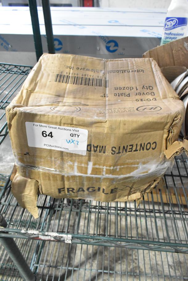 Damaged box labeled "International Tableware Dover Plate 11" contains scratch and dent dinnerware, including Acope Bowls. Auction tag with lot number 64 attached.