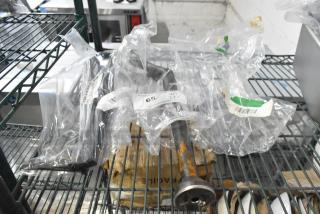 Brand new scratch and dent items on shelf, including Continental Refrigerator CM6-0907 Evaporator Drain Pan, Imperial 38052 Burner, Turbo Air 30226L0101 Door Handle. Each item bagged with visible tags.