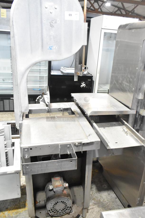 Commercial floor style meat saw, metal construction, used condition, 208-220/440 volts, includes label with model details.