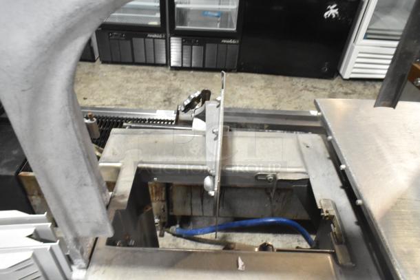 Commercial floor-style meat saw, stainless steel, operates at 208-220/440 volts. Shows moderate wear, suitable for heavy-duty use.