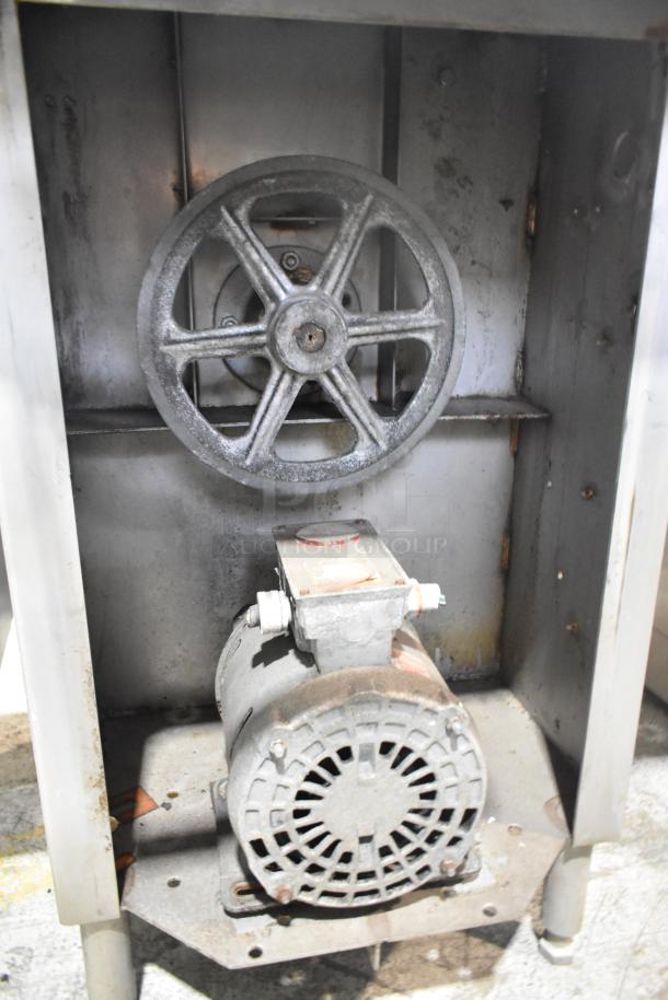 Commercial floor-style meat saw, shows motor and pulley system. Operates at 208-220/440 volts. Rust present, needs maintenance.
