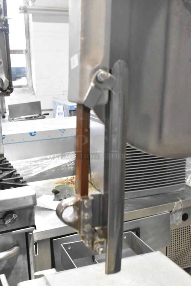 Commercial floor style meat saw, silver finish. Operates on 208-220/440 volts. Sturdy build, ideal for butchery tasks.